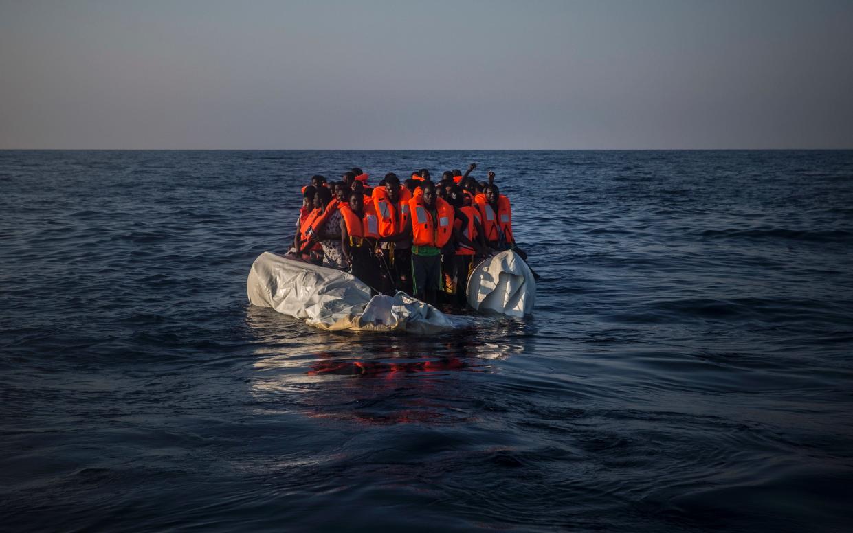 Migrants wait aboard a partially punctured rubber boat during a rescue operation on the Mediterranean Sea - Copyright 2016 The Associated Press. All rights reserved.