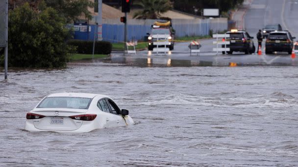 PHOTO: An abandoned car sits trapped on the street in overflow water from the San Diego River in San Diego, Calif., on Jan. 16, 2023. (Mike Blake/Reuters)