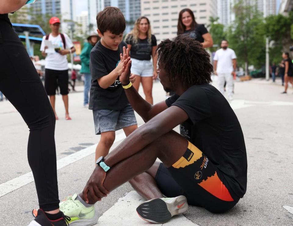 Tommy Cardenas, 21, from Integrity Tech, high fives a kid after winning the Mercedes-Benz Miami Corporate Run starting at Bayfront Park in Miami on Thursday, April 28, 2022.