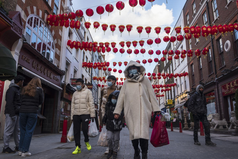 People wearing face masks as a preventive measure against the spread of covid-19 walk along the Street of China Town in London. Chinese New Year is the biggest festival in Asia. Every year, hundreds of thousands of people usually descend on the West End in London to enjoy a colorful parade, free stage performances and traditional Chinese food, and to wish each other "Xin Nian Kuai Le" (Happy New Year in Mandarin) or "San Nin Faai Lok" (in Cantonese). Due to national lockdown restrictions, people can enjoy London's Chinese New Year entertainment from home with an online celebration of past Chinese New Year festivities, alongside performances from emerging Chinese artists. (Photo by May James / SOPA Images/Sipa USA)