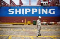 A labourer stand in front a new ship at Shanghai Waigaoqiao Shipbuilding Co., Ltd. in Shanghai, China June 15, 2017. Picture taken June 15, 2017. REUTERS/Aly Song