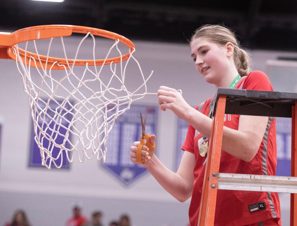 Northwest's Lily Bottomley cuts a piece of the net after defeating Canfield in a Division II girls basketball regional final at Barberton High School on Friday, March 3, 2023.