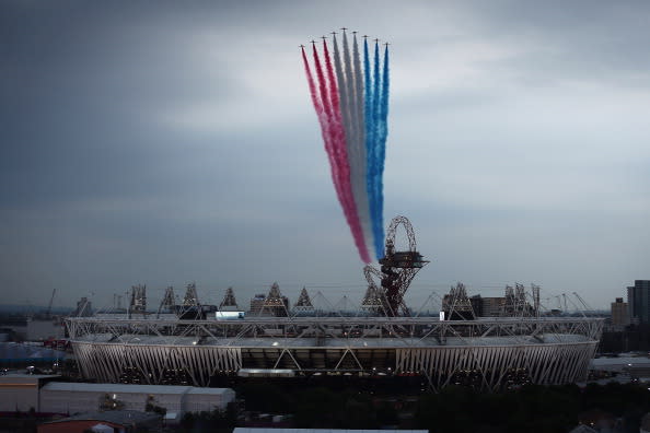 LONDON, ENGLAND - JULY 27: The Red Arrows fly over the Olympic Stadium and the ArcelorMittal Orbit Tower ahead of the opening ceremony of the 2012 London Olympic Games on July 27, 2012 in London, England. Athletes, heads of state and dignitaries from around the world have gathered in the Olympic Stadium for the opening ceremony of the 30th Olympiad. London plays host to the 2012 Olympic Games which will see 26 sports contested by 10,500 athletes over 17 days of competition. (Photo by Dan Kitwood/Getty Images)