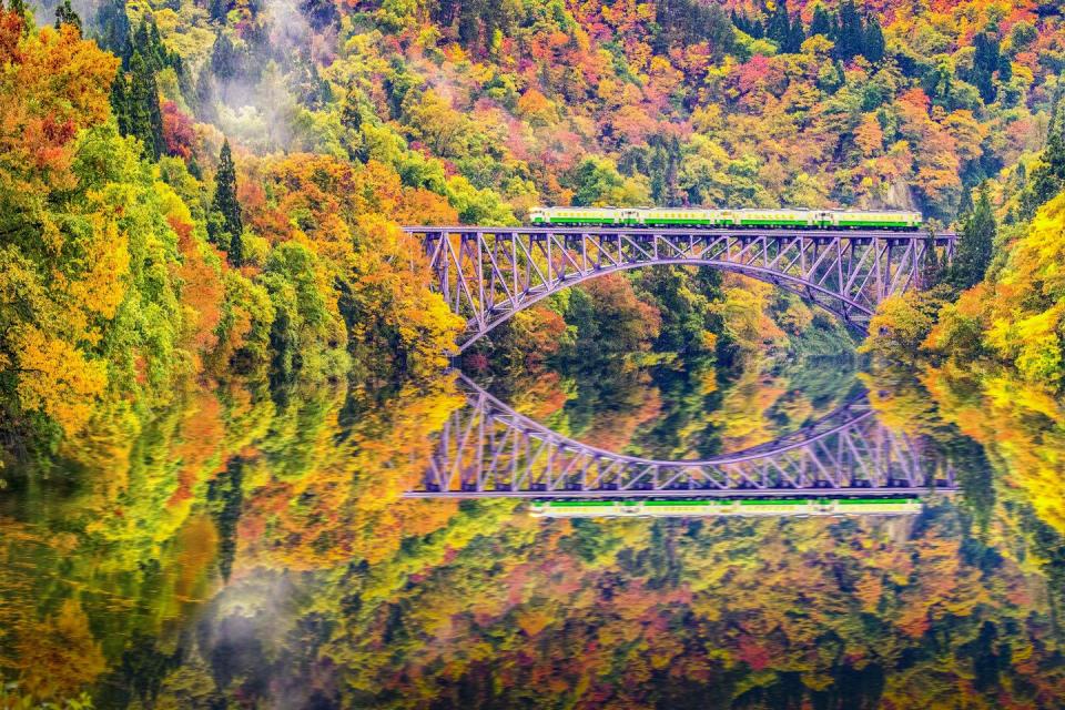 <p>A Tadami Line Train runs over the Tadami River in Japan.</p>