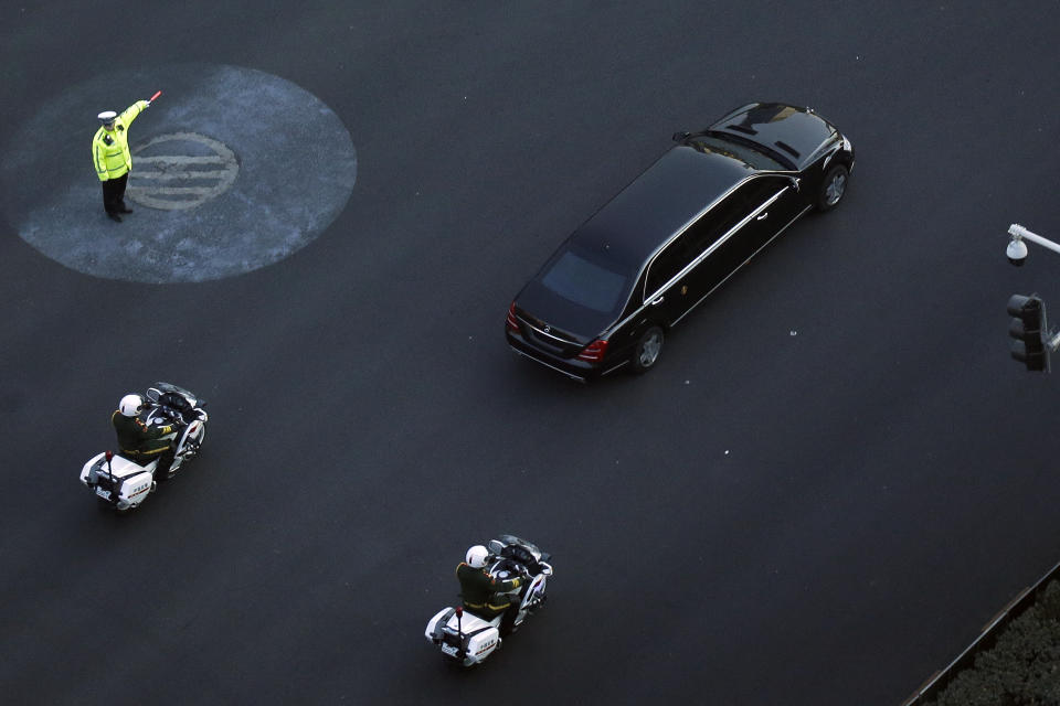 A traffic policeman shows direction to a Mercedes limousine with a golden emblem, similar to one North Korean leader Kim Jong Un has used previously, is escorted by motorcades traveling past Chang'an Avenue in Beijing, Wednesday, Jan. 9, 2019. North Korean state media reported Tuesday that Kim is making a four-day trip to China in what's likely an effort by him to coordinate with his only major ally ahead of a summit with U.S. President Donald Trump that could happen early this year. (AP Photo/Andy Wong)