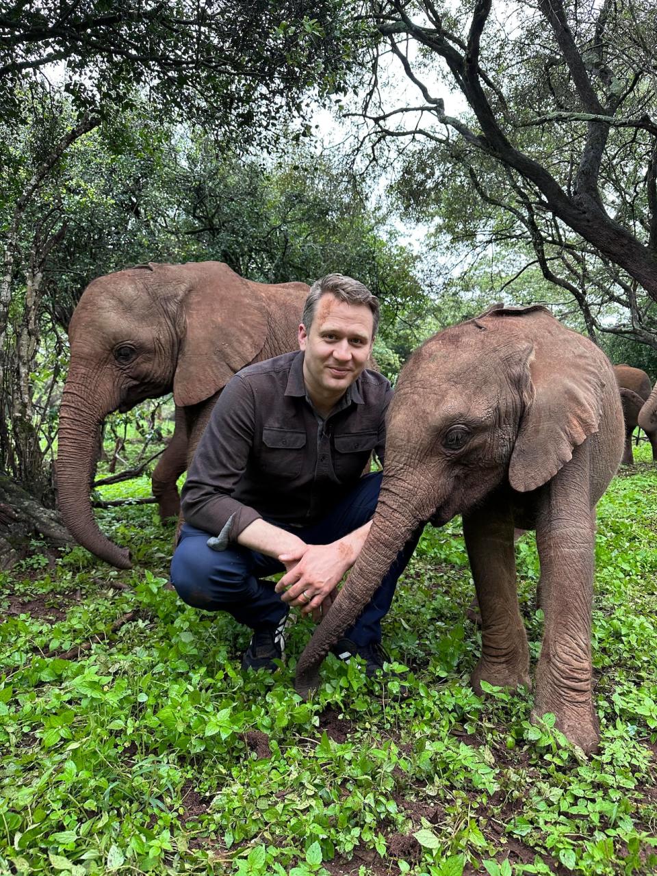 David Common on assignment in Kenya, with baby elephants. 