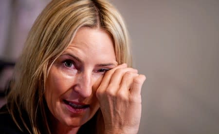Kelly Pfaff wipes tears from her eyes as she talks about her husband John's death during an interview at her home in Park City