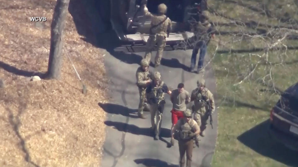 This image made from video provided by WCVB-TV, shows Jack Teixeira, in T-shirt and shorts, being taken into custody by armed tactical agents in Dighton, Mass. on April 13, 2023.<span class="copyright">WCVB-TV/AP</span>