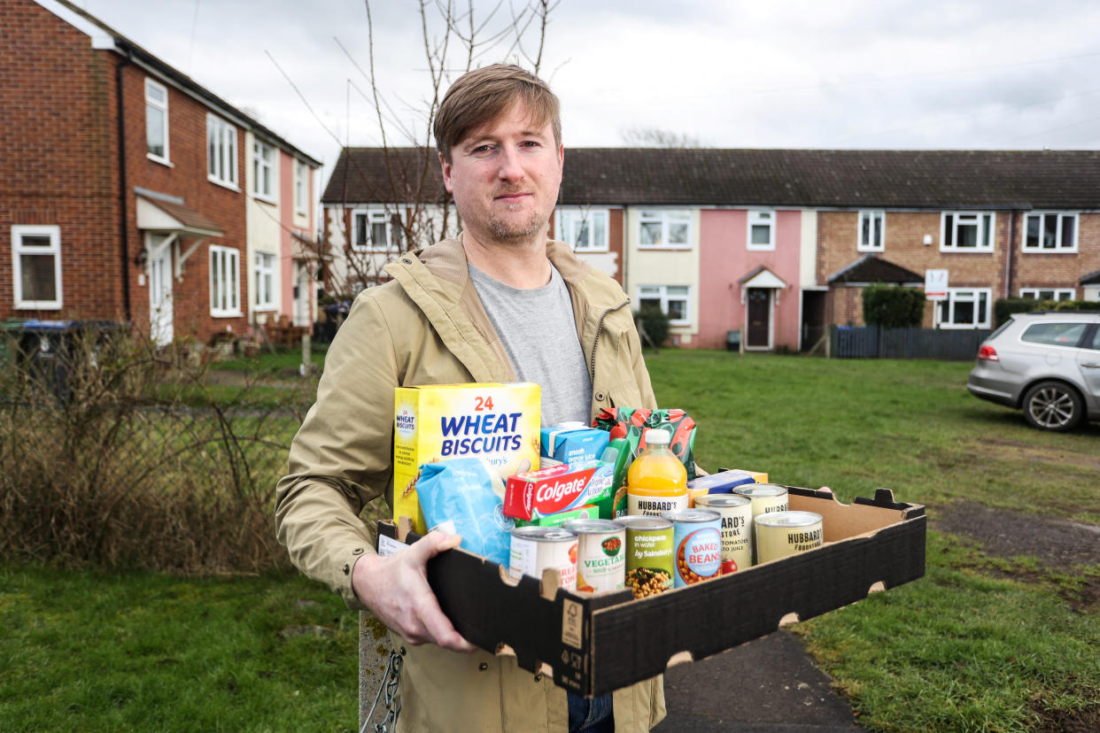 Harry Lay, 36, with a foodbank package in Cricklade, Wiltshire. (SWNS)