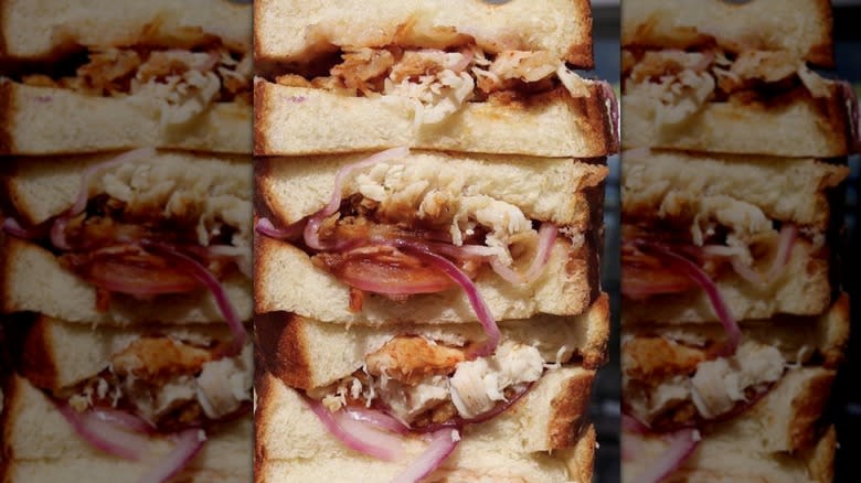 Stacked deli sandwiches with turkey and red onion