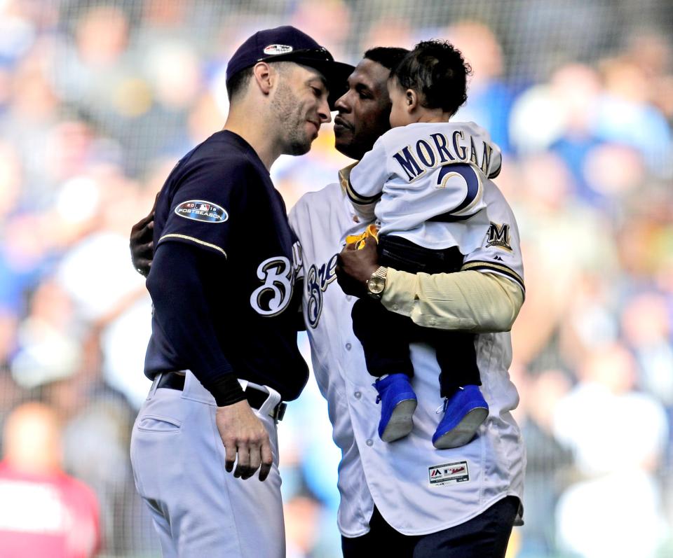 Nyjer Morgan is greeted by Ryan Braun after Morgan threw out the ceremonial  first pitch before Game 1 of the National League Division Series between the  Brewers and Rockies. It was a special moment because Morgan drove in the winning run in the 10th inning of final game of the Brewers' previous NLDS appearance in 2011.