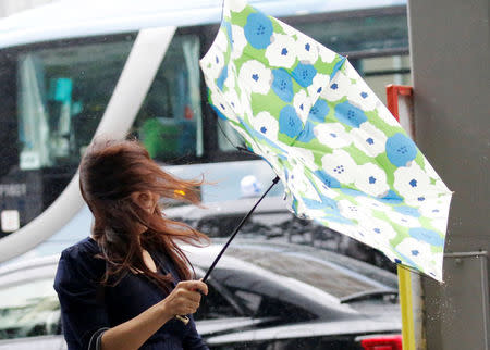 A woman using an umbrella struggles against a heavy rain and wind as Typhoon Shanshan approaches Japan's mainland in Tokyo, Japan August 8, 2018. REUTERS/Toru Hanai