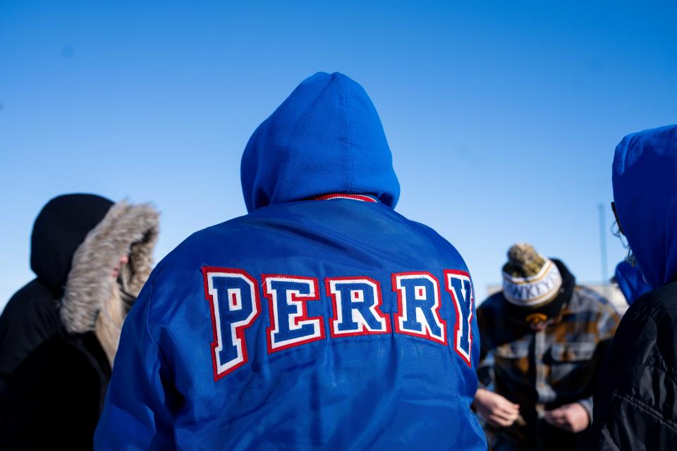 Community members mourn the loss of Perry High Principal Dan Marburger as his body is returned to town on Tuesday.