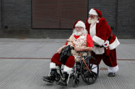 <p>A man helps another man in a wheelchair as they are dressed as Santa Claus during the World Santa Claus Congress, an annual event held every summer in Copenhagen, Denmark, July 23, 2018. (Photo: Andrew Kelly/Reuters) </p>