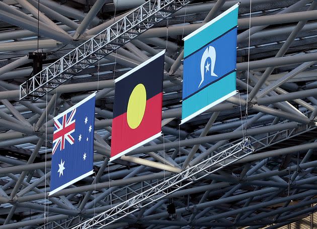 From left, the Australian flag, Aboriginal flag and Torres Strait Islander flag hang inside Sydney's Accor Stadium ahead of the first FIFA World Cup game in Australia.