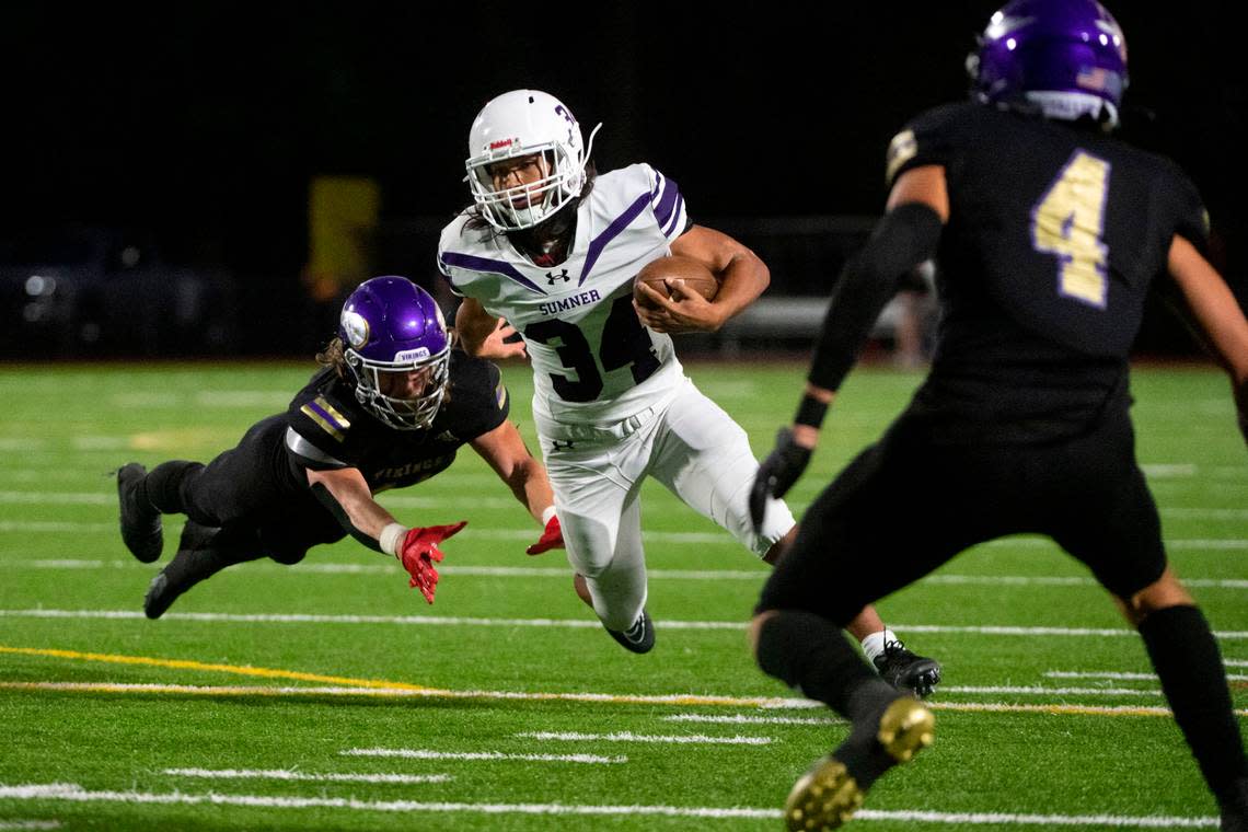 Sumner running back Steele Isaaccs escapes a tackle attempt by Puyallup’s Andrew Cody as he runs up field during the second quarter of a 4A SPSL game on Friday, Sept. 23, 2022, at Sparks Stadium in Puyallup, Wash.