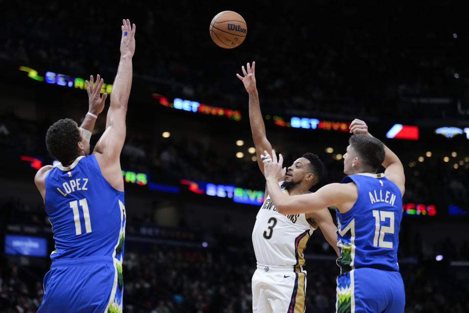 New Orleans Pelicans guard CJ McCollum (3) shoots between Milwaukee Bucks center Brook Lopez (11) and guard Grayson Allen (12) in the second half of an NBA basketball game in New Orleans, Monday, Dec. 19, 2022. The Bucks won 128-119. (AP Photo/Gerald Herbert)