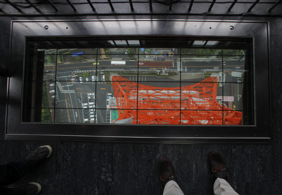 This photo taken Tuesday, June 12, 2012 shows visitors on the observation deck of Tokyo Tower in Japan. The Tokyo tourist experience is more affordable than the perception of an expensive city might suggest. Admission to the Tokyo Tower is only $10 and a visit to the Sensoji Temple, an important cultural site, is free. (AP Photo/Itsuo Inouye)