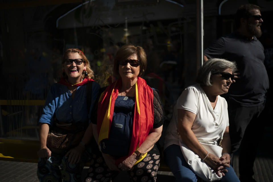 Supporters wearing Spanish flags watch as members of National Police and Guardia Civil march during a protest demanding better pay in Barcelona, Spain, Saturday, Sept. 29, 2018. (AP Photo/Felipe Dana)