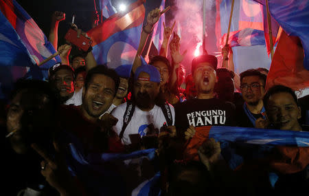 Supporters of Mahathir Mohamad, former Malaysian prime minister and opposition candidate for Pakatan Harapan (Alliance of Hope), celebrate outside the hotel, where Mahathir Mohamad held news conference, in Petaling Jaya, Malaysia, May 10, 2018. REUTERS/Athit Perawongmetha