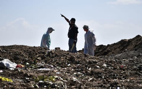 Forensic experts work at the crash site of an Ethiopian airways operated by a Boeing 737 MAX aircraft on March 16 - Credit:  TONY KARUMBA/ AFP