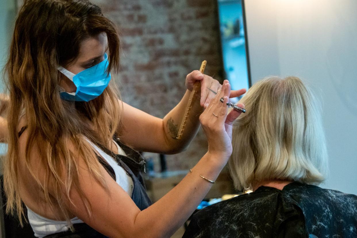 beauty salon hair stylist coronavirus A cosmetologist styles a customers hair at Parlour Salon as beauty salons, barber shops and spas begin to reopen in the wake of the Coronavirus COVID-19 pandemic, Wednesday, May 20, 2020, in Cincinnati, Ohio, United States. (Photo by Jason Whitman/NurPhoto via Getty Images)