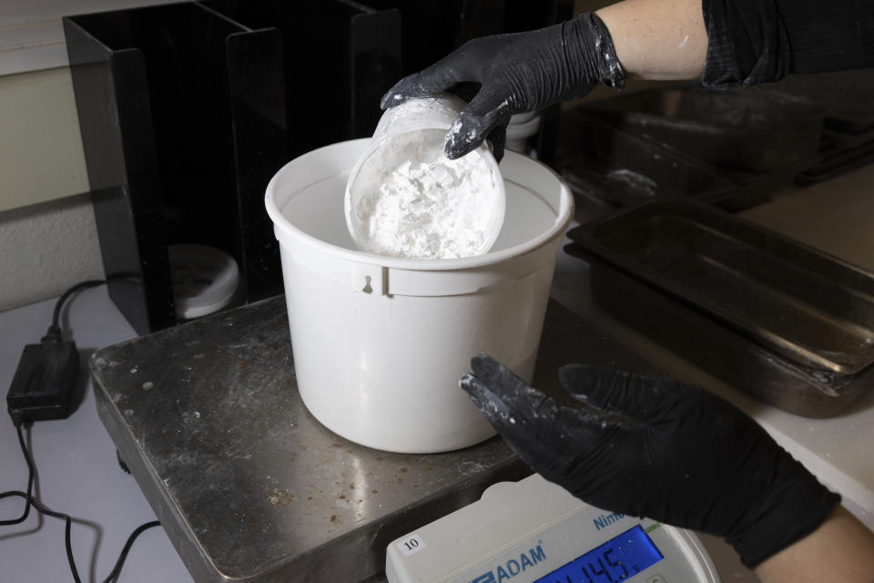 A worker measures ReAct product at Fortera's facility in San Jose, Calif., Wednesday, April 10, 2024. The cement industry is one of the largest emitters of carbon dioxide and is responsible for about 8% of global emissions each year. Fortera, a clean tech company whose technology captures carbon emissions from kilns and feeds it back in to the process, is opening its first commercial scale operation on Thursday, April 12, 2024, in California. (AP Photo/Benjamin Fanjoy)