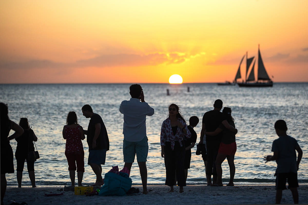 People watch a sunset at the beach.