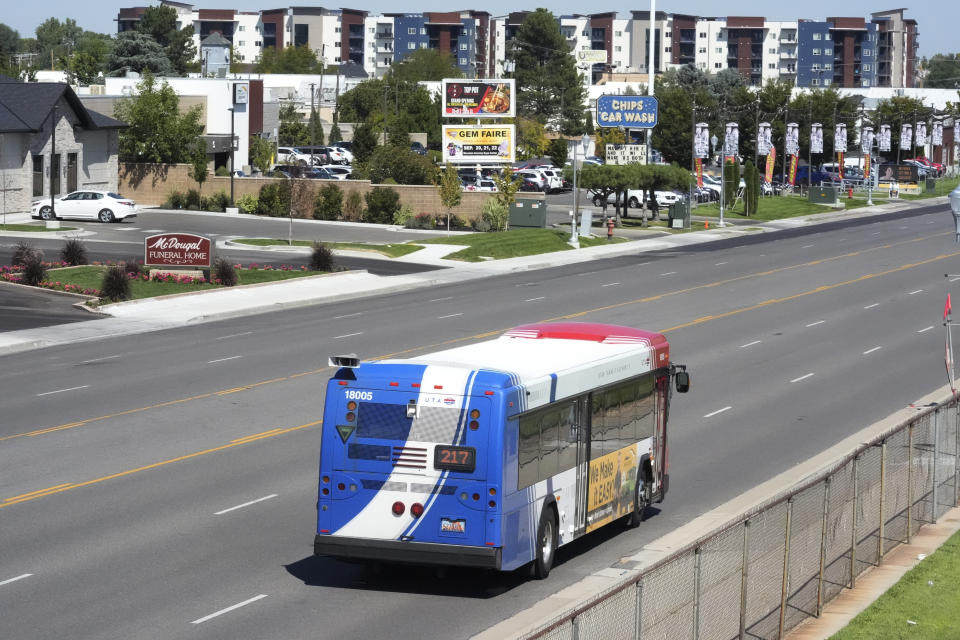 A commuter bus equipped with a radio transmitter passes a connected traffic light on Redwood Road, part of an effort to improve safety and efficiency by allowing cars to communicate with the roadside infrastructure and one another, Friday, Sept. 6, 2024, near Taylorsville, Utah. (AP Photo/Rick Bowmer)