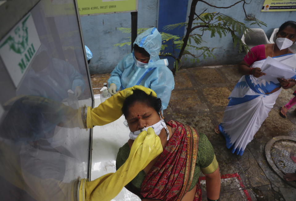 A health worker takes a nasal swab sample at a COVID-19 testing center in Hyderabad, India, Saturday, Nov. 28, 2020. India has more than 9 million cases of coronavirus, second behind the United States. (AP Photo/Mahesh Kumar A.)