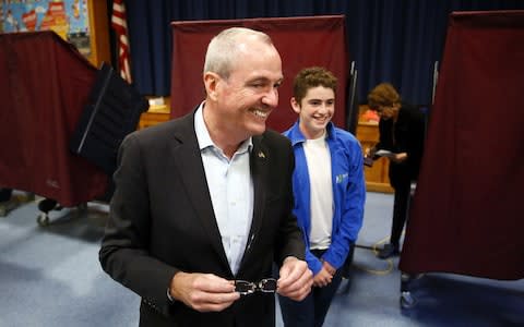 Democrat Phil Murphy exits the polling booth with his youngest son Sam, after voting at the Fairview School on Tuesday, Nov. 7, 2017 in Middletown, N.J. - Credit: AP