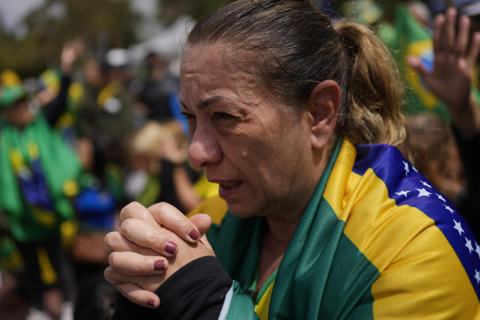 A supporter of Brazilian President Jair Bolsonaro prays during a protest against his defeat in the country's presidential runoff, outside a military base in Sao Paulo, Brazil, Thursday, Nov. 3, 2022. Some supporters are calling on the military to keep Bolsonaro in power, even as his administration signaled a willingness to hand over the reins to his rival, President-elect Luiz Inacio Lula da Silva. (AP Photo/Matias Delacroix)