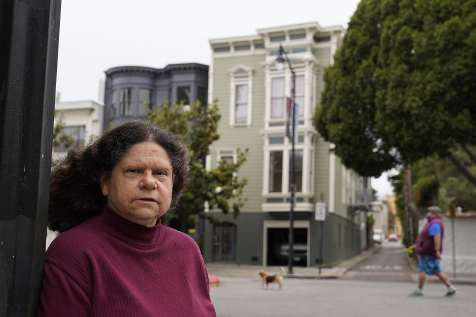 Census taker Linda Rothfield poses across the street from an apartment building she was unable to access in San Francisco, on Wednesday, June 30, 2021. Some census takers worry that renters in apartment buildings were not tallied fully during the nation's head count last year. Census takers say they had difficulty entering apartment buildings due to COVID restrictions, and they weren't able to get in touch with landlords for help. (AP Photo/Eric Risberg)