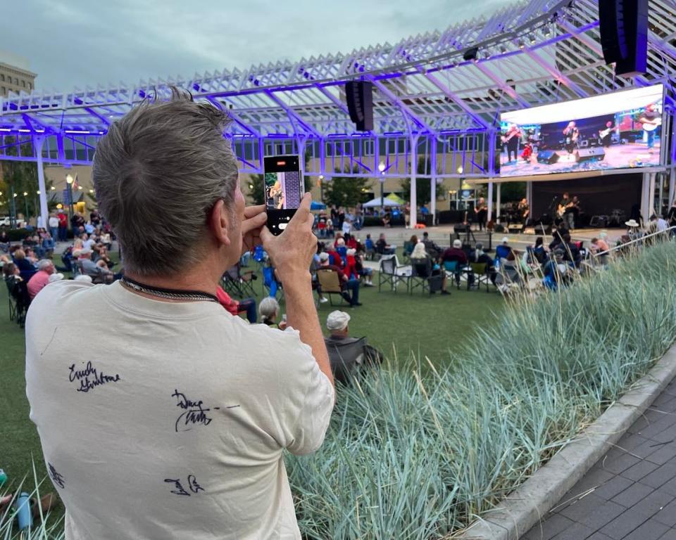 A rock 'n' roll fan records video on Friday night at Centennial Plaza during the Downtown Canton Music Fest.
