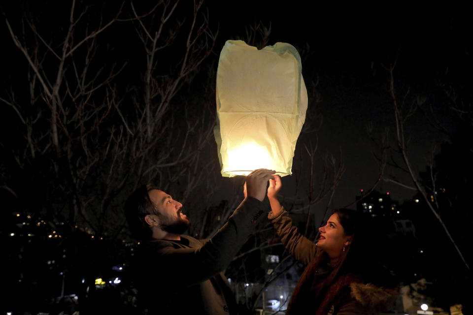 People fly a wishing lantern ahead of the Persian New Year, or Nowruz, meaning "New Day." in Tehran, Iran, Monday, March 15, 2021. (AP Photo/Ebrahim Noroozi)