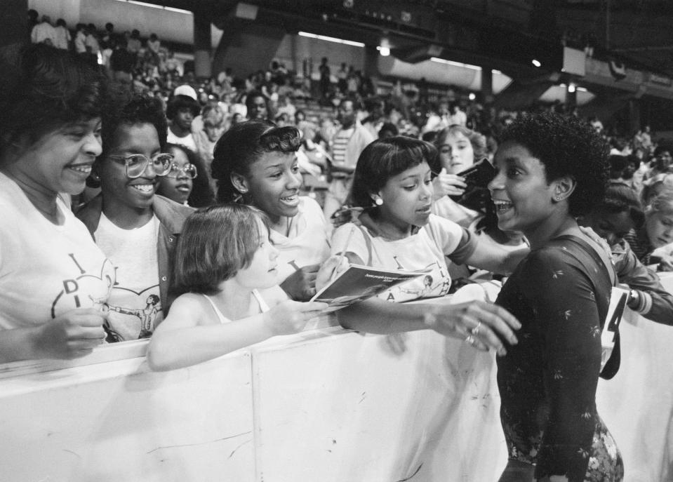 Dianne Durham, 15, of Gary, Ind., right, signs autographs after winning the women's title at the McDonald's U.S.A. Gymnastic Championships at the University of Illinois in Chicago, June 5, 1983. She is the first Black woman to win a major national gymnastics title. (AP Photo/Lisa Genesen)