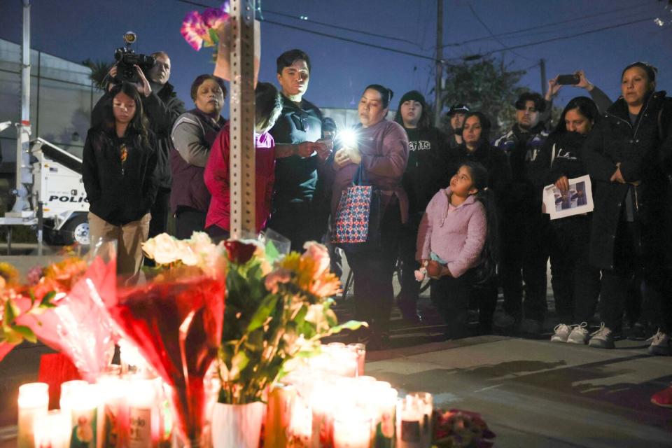 People stand at a candlelight vigil.