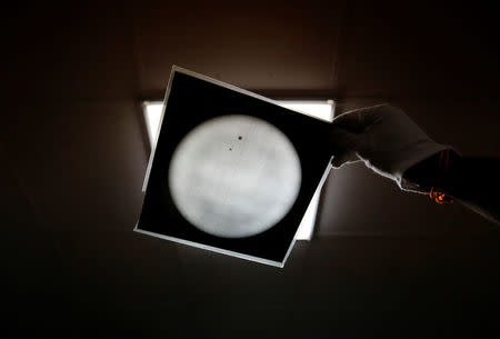 A technician holds the photographic film plate with observational data inside the archival digitisation lab at the Kodaikanal Solar Observatory, India, February 3, 2017. REUTERS/Danish Siddiqui