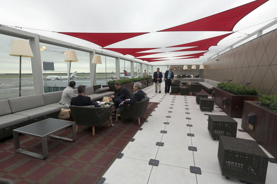 Passengers wait for their flight in the outdoor patio in the Delta airlines Sky club at terminal 4 at JFK airport, Friday, May 24, 2013 in New York. Delta opened its new $1.4 billion terminal, strengthening its hand in the battle for the lucrative New York travel market. The expanded concourse offers sweeping views of the airport, upscale food and shopping options and increased seating. It replaces a decrepit terminal built by Pan Am in 1960 that was an embarrassing way to welcome millions of visitors to the United States. (AP Photo/Mary Altaffer)