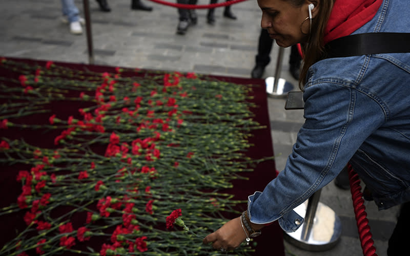 People put flowers over a memorial placed on the spot of Sunday's explosion on Istanbul's Istiklal Avenue