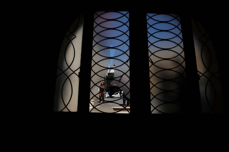 A Palestinian woman walks next to a broken door of the Andrews Episcopal Church, in Ramallah in the Israeli-Occupied West Bank