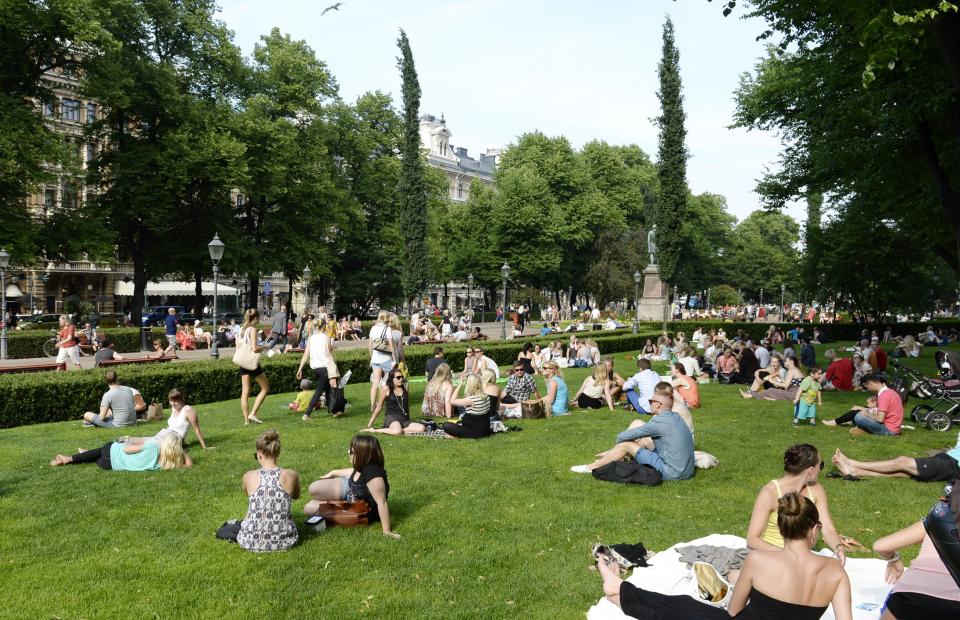 In this June 26, 2013 photo, people cool off on a hot summer day in Esplanade Park in Helsinki, Finland. In summer, glorious sun-filled days draw picnickers to every available last patch of grass. (AP Photo/Lehtikuva, Martti Kainulainen) FINLAND OUT