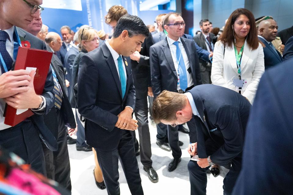 Prime Minister of Sweden, Ulf Kristersson (right), writes down his contact details for Prime Minister Rishi Sunak during the Cop27 summit at Sharm el-Sheikh, Egypt. (PA)