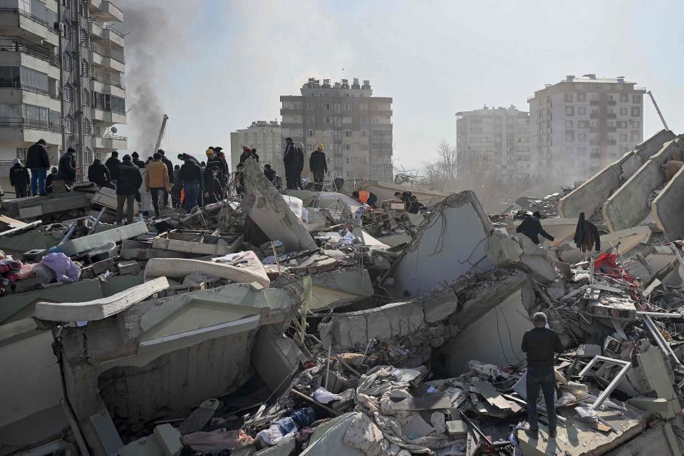 People wait as rescuers search for victims and survivors among the rubble of collapsed buildings in Kahramanmaras (AFP via Getty Images)