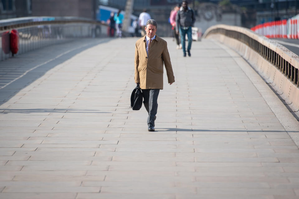 A man walks over London Bridge towards the City financial district during what would normally be morning rush hour, as the UK continues in lockdown to help curb the spread of the coronavirus.