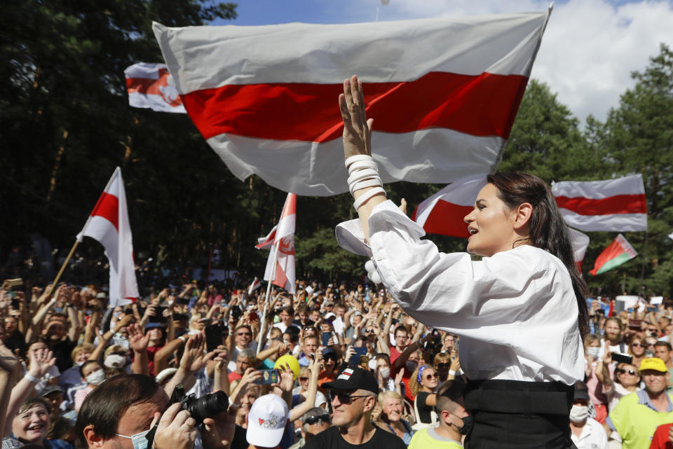 FILE - In this file photo taken on Sunday, Aug. 2, 2020, Sviatlana Tsikhanouskaya, candidate for the presidential elections greets people waving old Belarus flags during a meeting to show her support in Brest, 326 km (203,7 miles) southwest of Minsk, Belarus. A former Soviet republic on the fault line between Russia and Europe is boiling with revolt this summer. Sounds familiar — but Belarus 2020 isn’t Ukraine 2014, and that’s why it’s hard to predict what will happen next. (AP Photo/Sergei Grits, File)