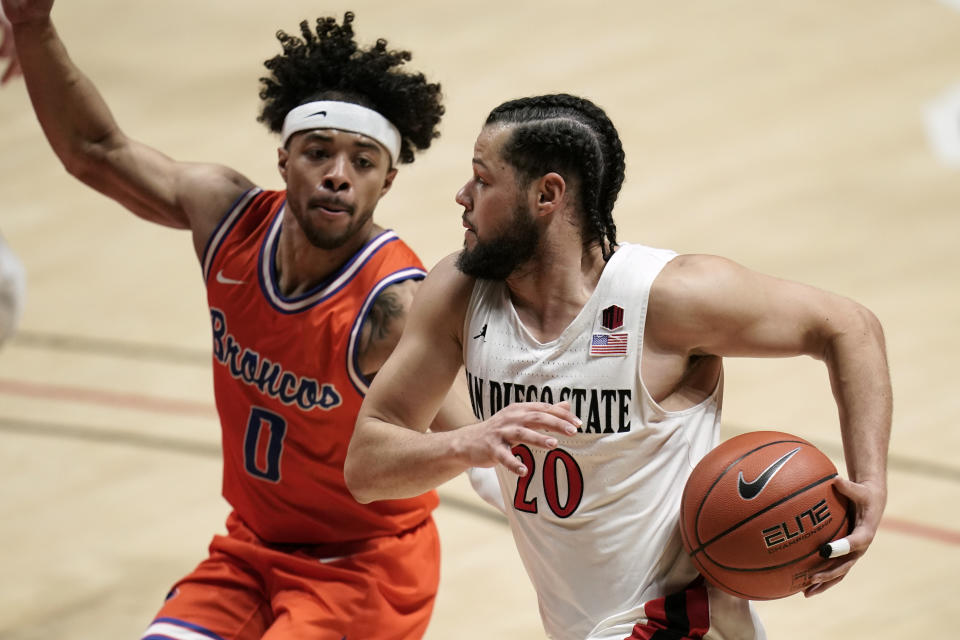 San Diego State guard Jordan Schakel (20) drives the ball against Boise State guard Marcus Shaver Jr. (0) during the first half of an NCAA college basketball game Saturday, Feb 27, 2021, in San Diego. (AP Photo/Gregory Bull)