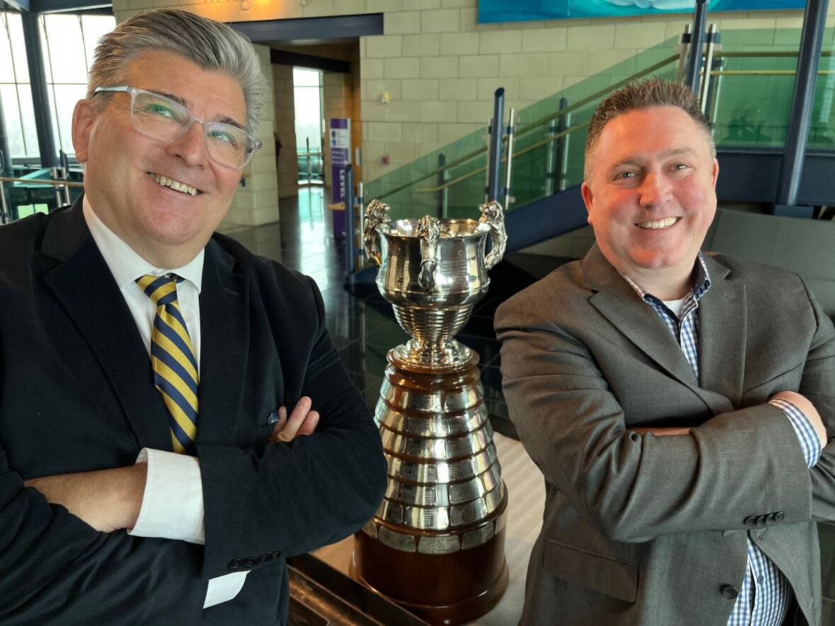 Stephen Handrigan, president of St. Bonaventure's College, and Michael Holden, manager of the school's Tier 2 hockey team, are proud to resurrect the Boyle Trophy.  (Terry Roberts/CBC - image credit)