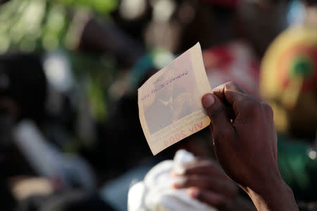 A supporter of Fanmi Lavalas party holds a picture of former President Jean-Bertrand Aristide during a rally of presidential candidate Maryse Narcisse ahead of the presidential election, in a street of Port-au-Prince, Haiti, November 17, 2016. The words on the back of the picture read, "Aristide, we still love you". REUTERS/Andres Martinez Casares