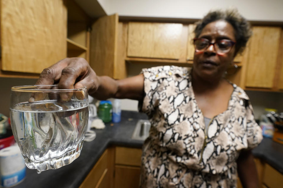 Mary Gaines a resident of the Golden Keys Senior Living apartments displays contaminated water in her kitchen in Jackson, Miss., Thursday, Sept. 1, 2022. A recent flood worsened Jackson's longstanding water system problems. (AP Photo/Steve Helber)